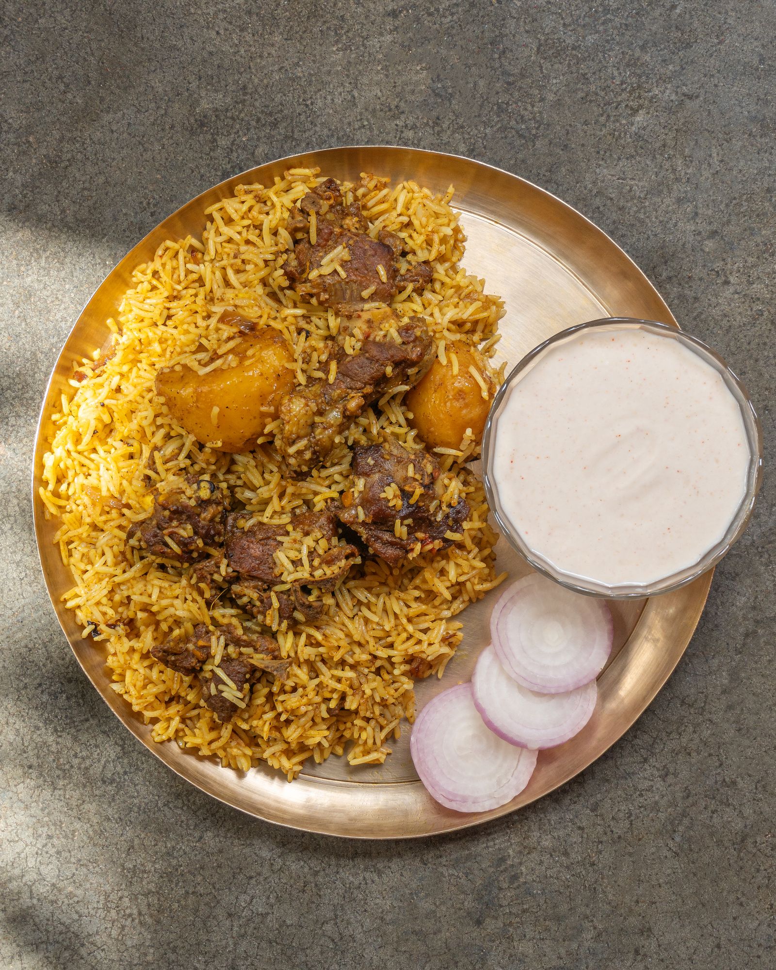 Real food photograph of beef biriyani with aromatic rice served on a golden platter